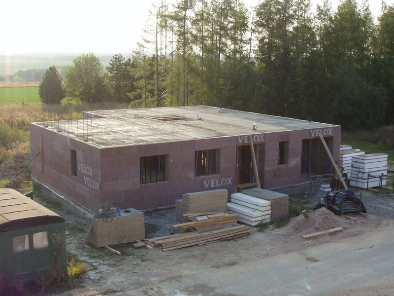 Vybetonovaná stropní deska s trčící výztuží v podvečerním protisvětle, 13. den