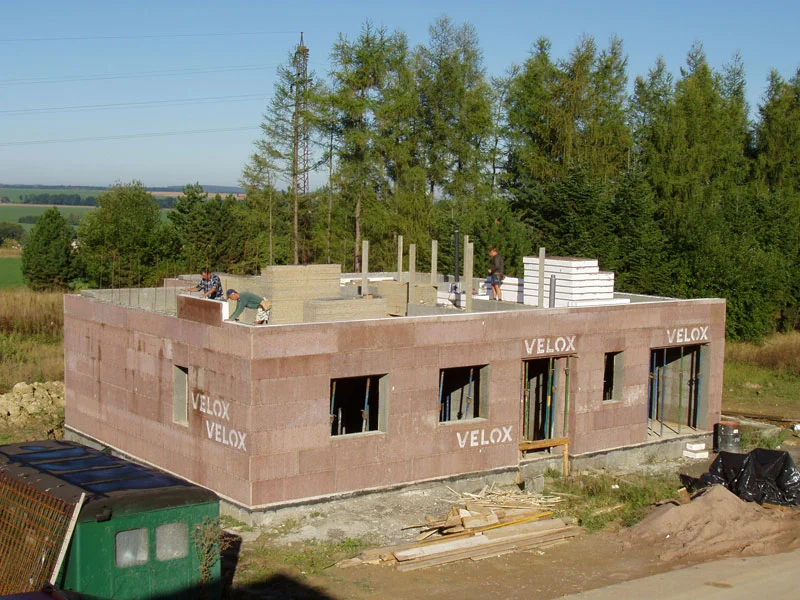 Dělníci staví vnitřní stěny na stropě rozestavěného domu, 15. den montáže