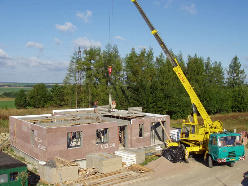 Autojeřáb ukládá stropní panely na hotové stěny bungalovu, 9. den montáže