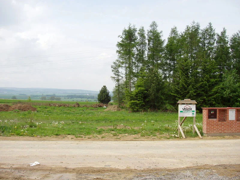 Stavební parcela s informační tabulí VELOX a zděným pilířem přípojek