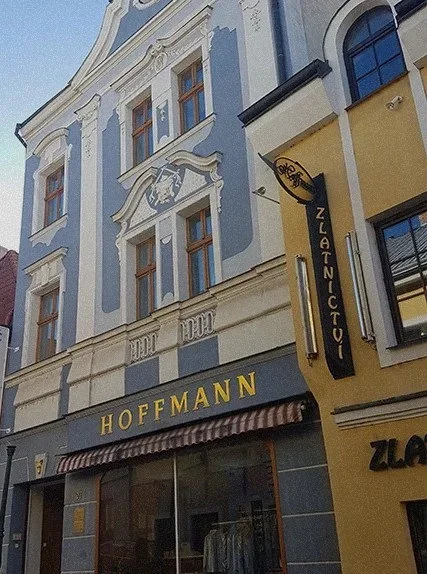 Historický městský dům s modrobílou zdobenou fasádou a nápisem HOFFMANN