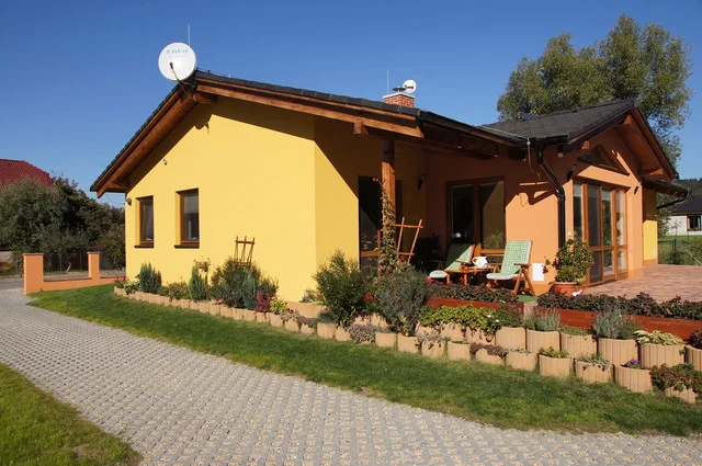Bungalov MINERVA II se žlutooranžovou fasádou a terasou