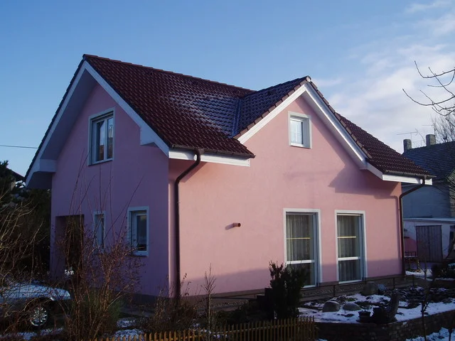 Rodinný dům MINI s růžovou fasádou a sedlovou střechou