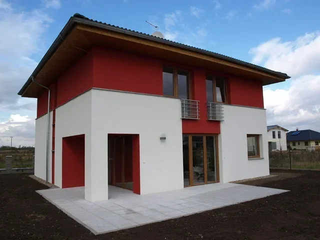Rodinný dům PRIMA – nároží s betonovou terasou a balkonem, slunečný den