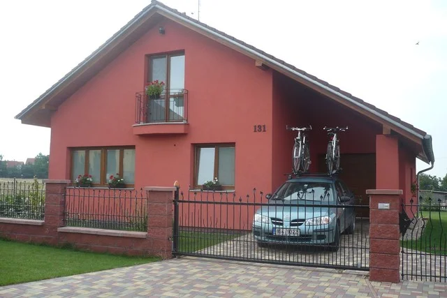 Dům VERONIKA v terakotové barvě s balkonem a garáží za kovaným plotem