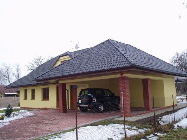 Dům FORTUNA se žlutou fasádou a krytým stáním s automobilem