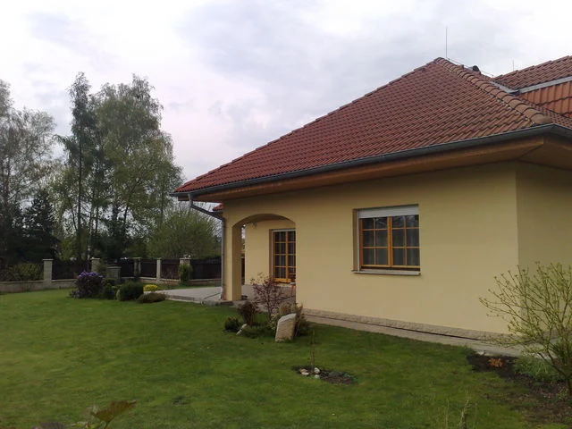 Boční pohled na dům AFRODITE se žlutou fasádou a klenutým vstupem
