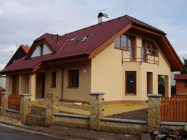 Dokončený dům HERA s okrovou fasádou před dokončením terénních úprav