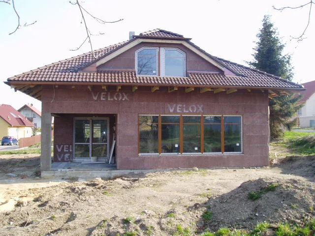 Stavba domu Charis s osazeným velkým oknem a arkýřovým oknem ve vikýři