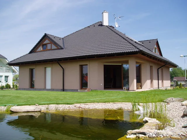 Dům Jupiter s béžovou fasádou a jezírkem v předním plánu