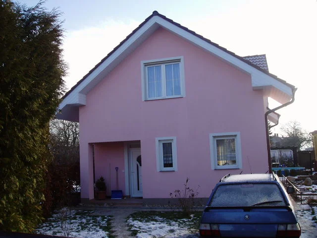 Růžový dům Mini od vstupu, krytý závětřím a vzrostlým živým plotem