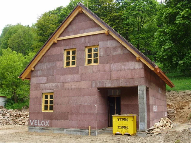 Štítové čelo hrubé stavby Mini se žlutými okenními rámy a nápisem VELOX