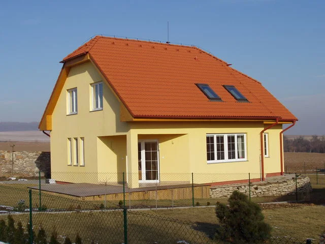 Realizovaný dům VENUS se žlutou fasádou a oranžovou polovalbovou střechou