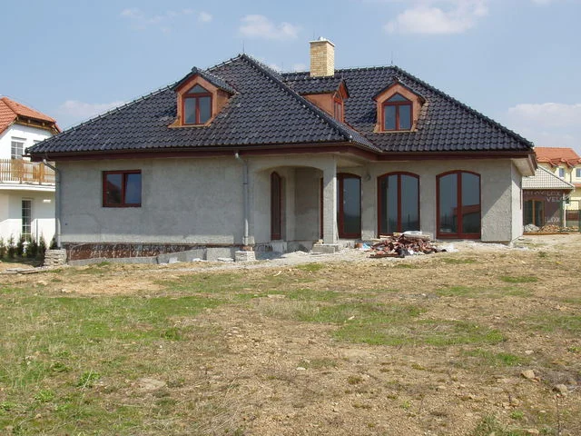 Dům AFRODITE s dokončenou černou střechou a dosud neomítnutou fasádou