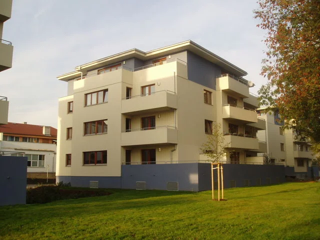 Bytový dům v Malešicích ve večerním světle, čtyři podlaží s balkony