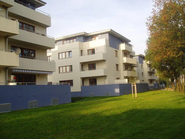 Bytové domy v Malešicích s balkony a travnatým parkem mezi objekty