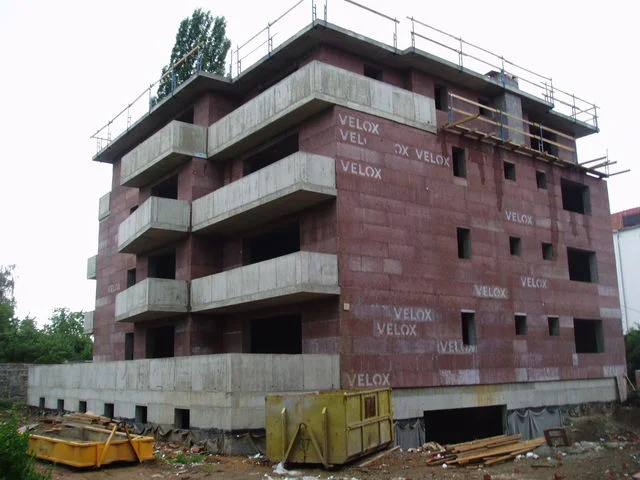 Čtyřpodlažní hrubá stavba VELOX s vybetonovanými balkony a lešením