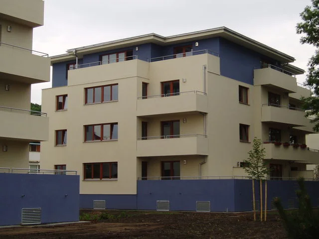 Čelní pohled na bytový dům v Malešicích s předsazenými balkony