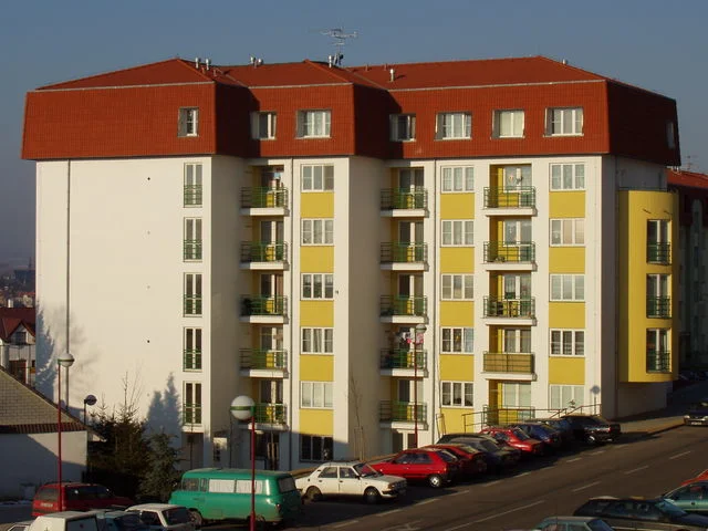 Bytový dům Větrník v Chrudimi se žlutobílou fasádou a červenou mansardovou střechou