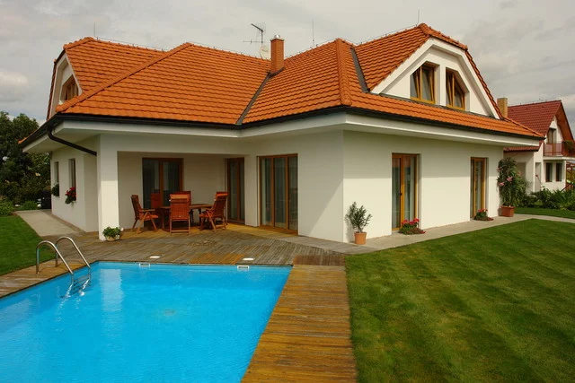 Rodinný dům FORTUNA s oranžovou střechou, dřevěnou terasou a bazénem