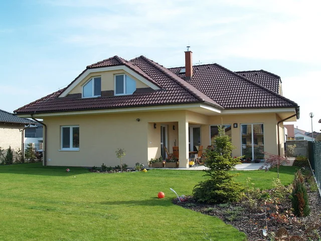 Rodinný dům FORTUNA s valbovou střechou a krytou terasou při pohledu ze zahrady