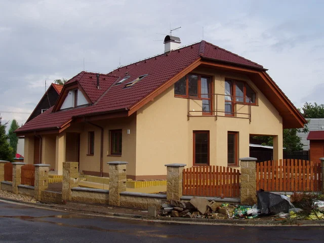 Rodinný dům HERA s okrovou fasádou, balkonem a červenou střechou